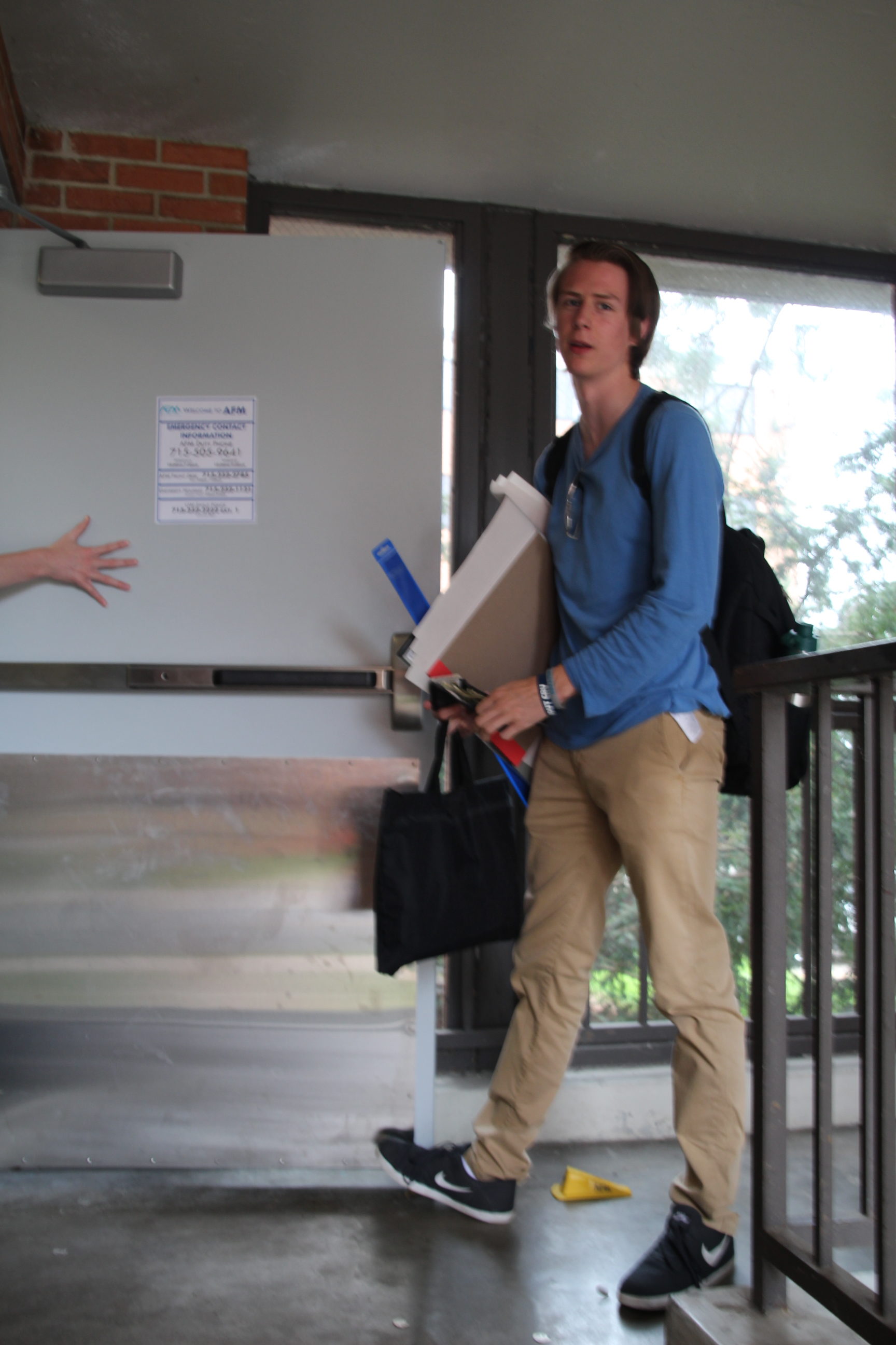 After using his card to gain access to AF, Sam Gersregen, a sophomore in the Graphics Design program, holds the door for his friends.